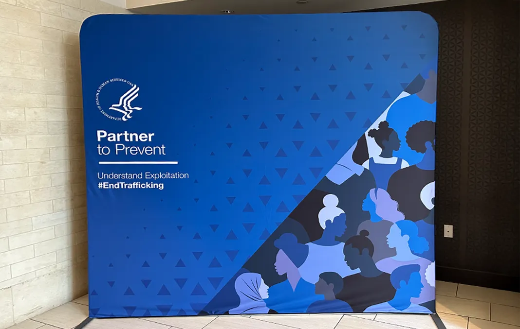 Trade show booth display featuring a banner for the Partner to Prevent: Understand Exploitation #EndTrafficking for the U.S. Department of Health and Human Services.