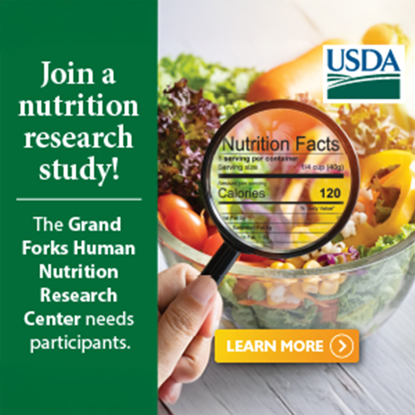 Advertisement published by USDA about The Grand Forks Human Nutrition Research Center showing a hand holding a magnifying glass to a nutrition label with a colorful salad in the background with text overlaid that reads 'Join a nutrition research study! The Grand Forks Human Nutrition Research Center needs participants.'
