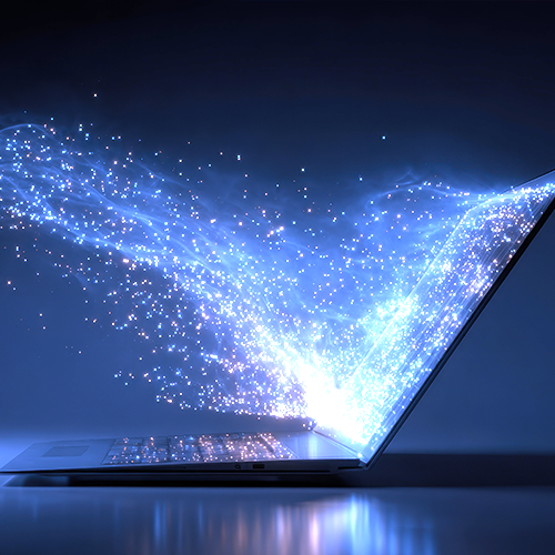 A laptop with sparkling light projecting from the screen conveying the transfer of technology.
